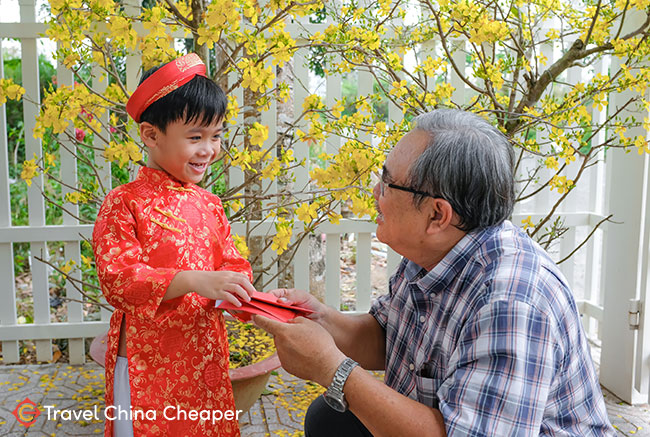 A grandparent gives a child a hongbao with money in China